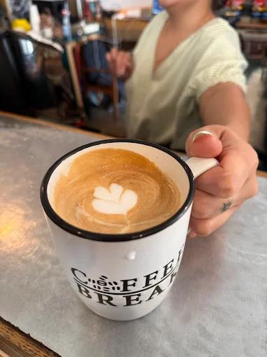 A caffe latte with a leaf in the foam
