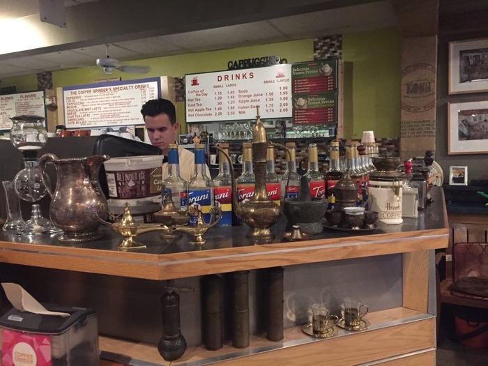 The coffee bar lined with brass coffee pots, Turkish grinders and syrup bottles under the drinks menu