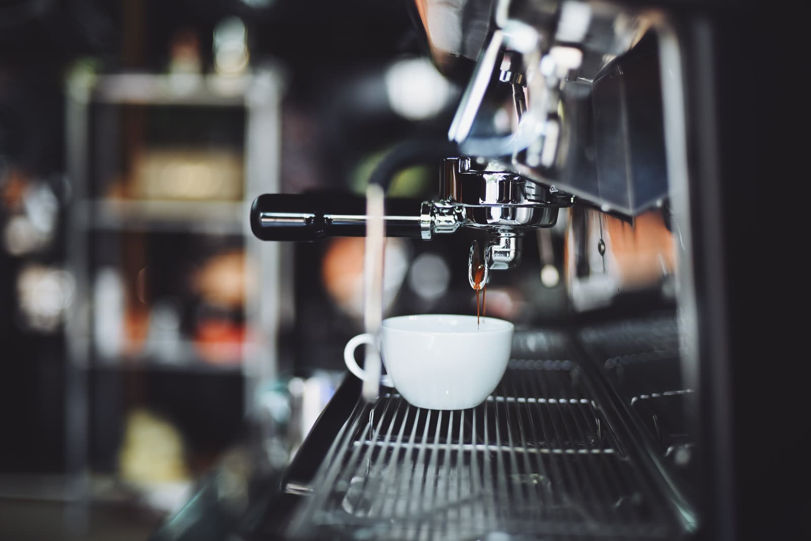 Espresso pouring from a machine into a white cup