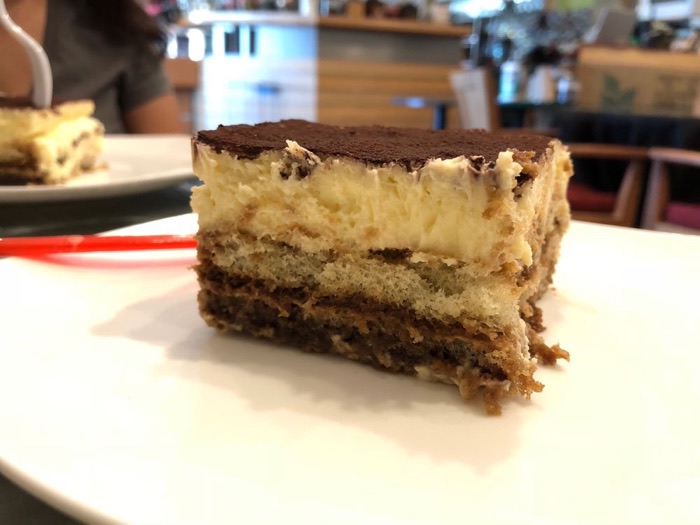 A slice of tiramisu on a white plate