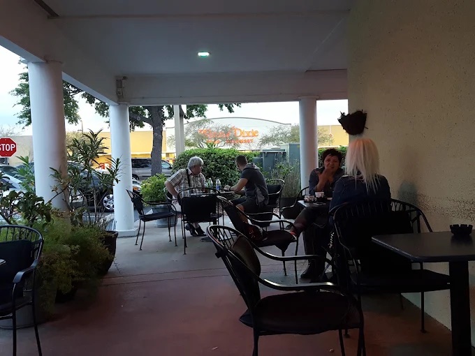 Friends talking at the covered patio tables at dusk