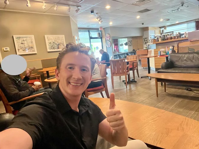 A customer giving a thumbs up from a table in the lounge